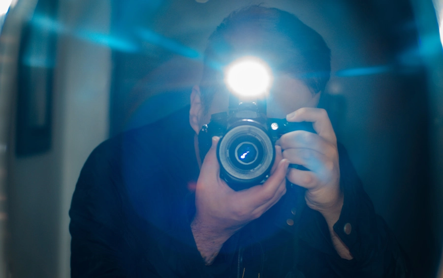 César Rosenow tomándose una selfie con su cámara y flash frente a un espejo César Rosenow tomándose una selfie con su cámara y flash frente a un espejo